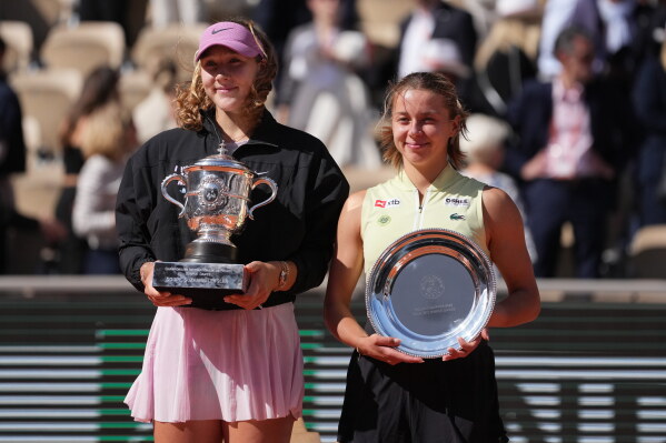 Winner Russia's Mirra Andreeva, left, and second placed Poland's Maja Chwalinska pose with trophies after the final tennis match at the French Open in Paris, Saturday, June 6, 2026. (AP Photo/Thibault Camus)