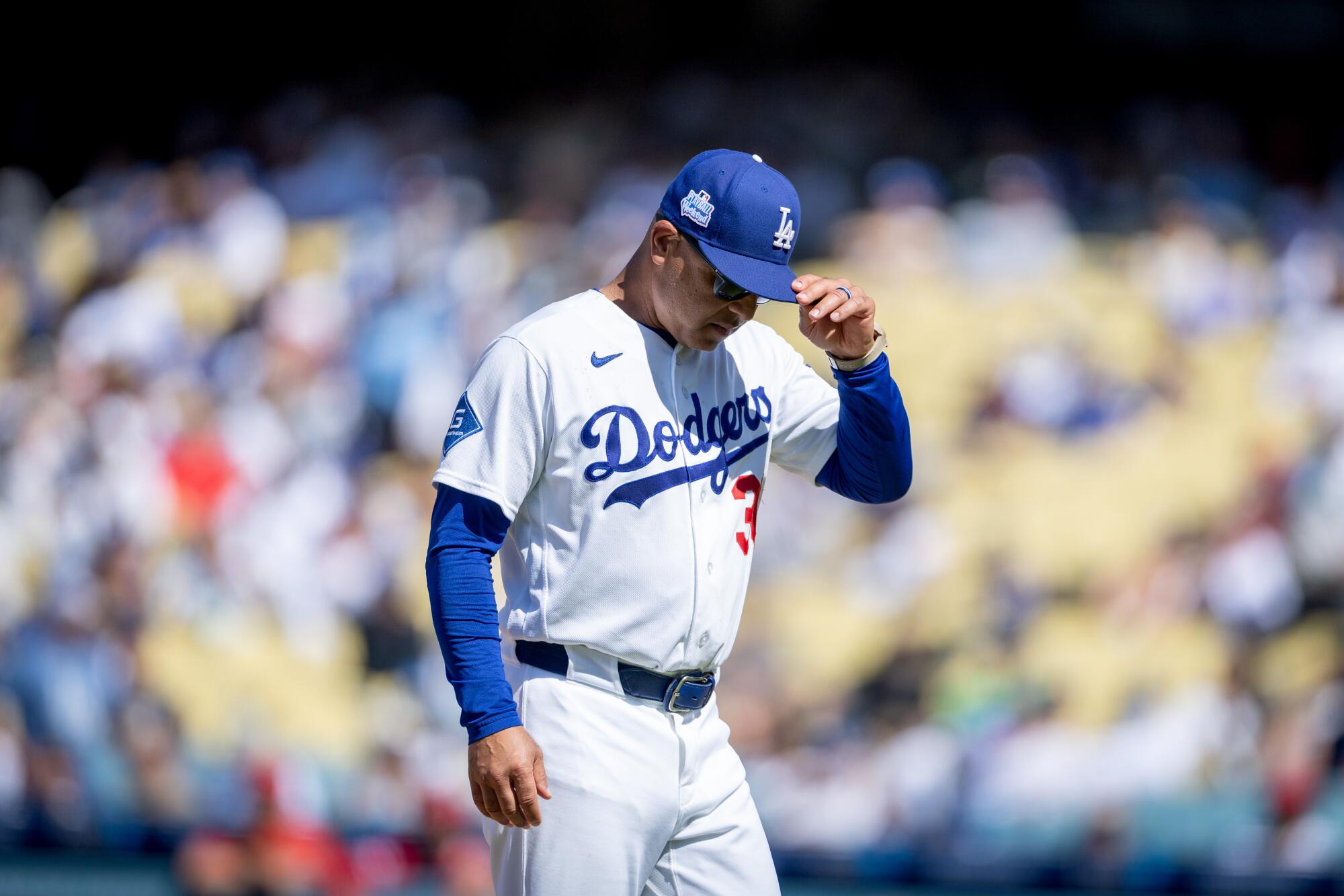 Dodgers manager Dave Roberts walks on the field during the seventh inning Sunday against the Angels.
