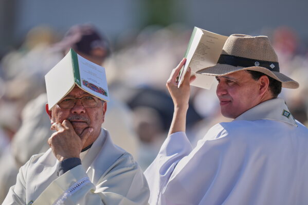 Priests wait for the arrival of Pope Leo XIV ahead of a Holy Mass and Corpus Christi procession at Plaza de Cibeles in Madrid, Spain, Sunday, June 7, 2026, on the second day of his seven-day apostolic visit to mainland Spain and the Canary Islands. (AP Photo/Manu Fernandez)