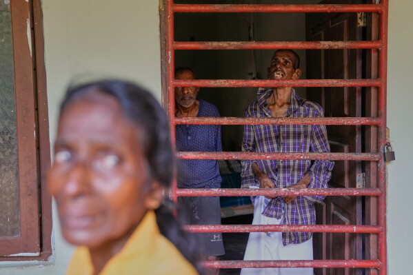 The mother of a resident stands outside a dormitory at a nursing home, where inmates of another nursing home that caught fire on Wednesday are being temporarily housed in Anguruwatota, Sri Lanka, Friday, June 5, 2026. (AP Photo/Eranga Jayawardena)
