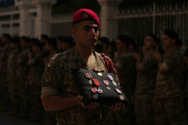 A Lebanese Army soldier carries the medals of Lebanese Brig. Gen. Wissam Sabra during his funeral procession in Beirut, Lebanon, Sunday, June 7, 2026, a day after Sabra was killed in an Israeli airstrike in south Lebanon along with a captain and another soldier, according to the Lebanese Army. (AP Photo/Hassan Ammar)