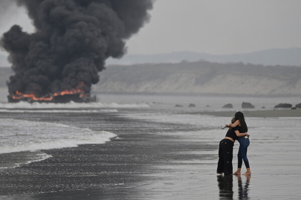 Fishing boats burn in Manta, Ecuador, Saturday, June 6, 2026. (AP Photo/Ariel Ochoa)