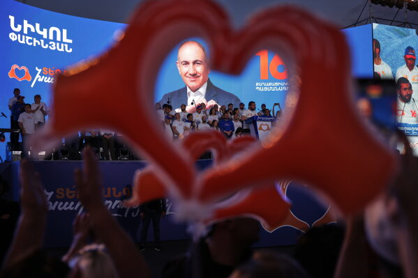 Supporters of Armenia's ruling Civil Contract party leading by Prime Minister Nikol Pashinyan hold up heart signs while gathering in Republic Square in Yerevan, Armenia, Friday, June 5, 2026, for the party's final campaign rally ahead of the upcoming parliamentary elections. (AP Photo/Anthony Pizzoferrato)