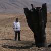 A man looks at the wreckage of an Iranian missile that landed near the West Bank city of Jericho on Monday.