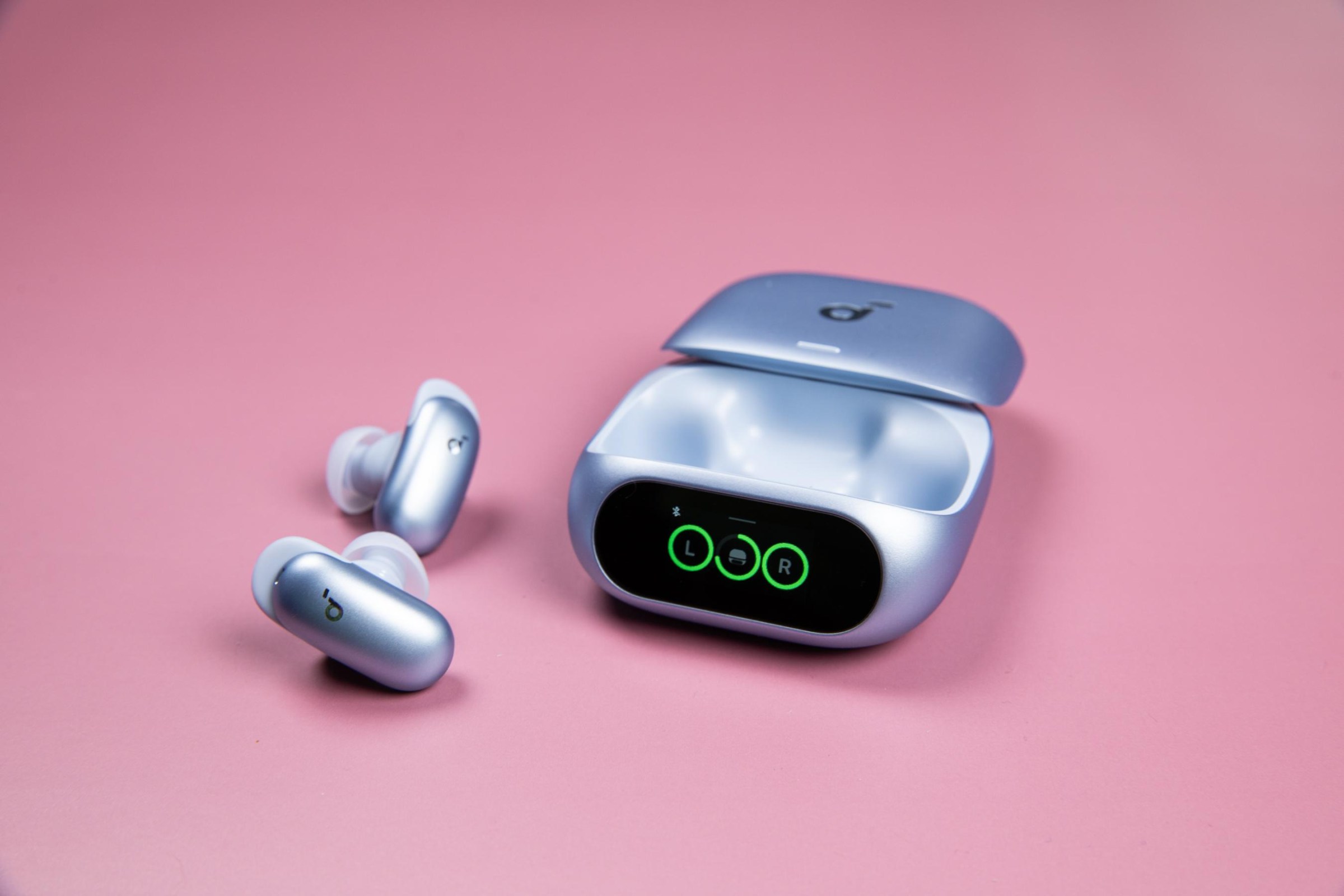 The blue Soundcore Liberty 5 Pro earbuds sitting next to their open case on a mauve background.