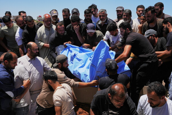 Mourners carry the body of one of four members of the al-Hariri family, a woman, her daughter and her two sons, killed in Israeli strikes in southern Lebanon, during their funeral in Busra al-Harir, in Syria's southern Daraa province, Wednesday, June 10, 2026. (AP Photo/Omar Albam)