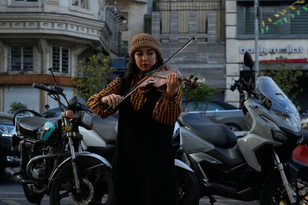 A street musician plays the violin on a sidewalk in northern Tehran, Wednesday, June 10, 2026. (AP Photo/Vahid Salemi)