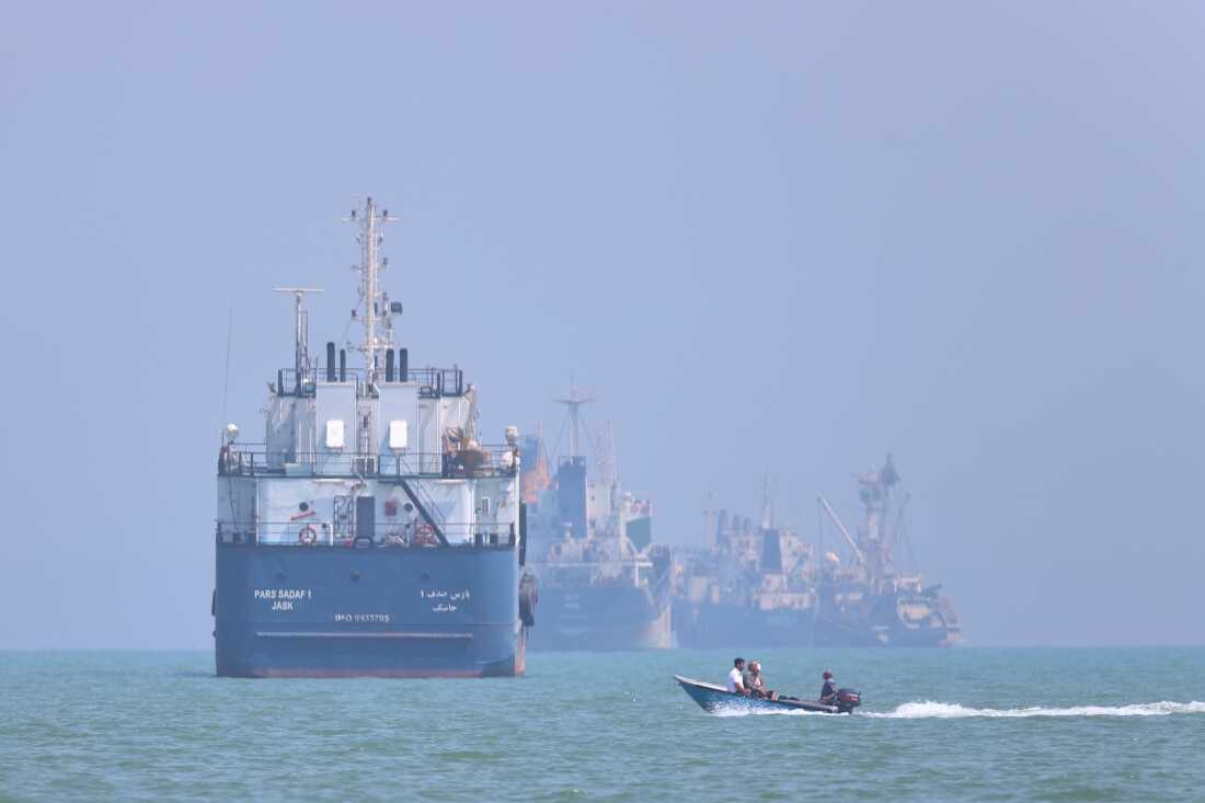 A small motorboat passes anchored vessels in the Strait of Hormuz off Bandar Abbas, Iran, Thursday, June 11, 2026.