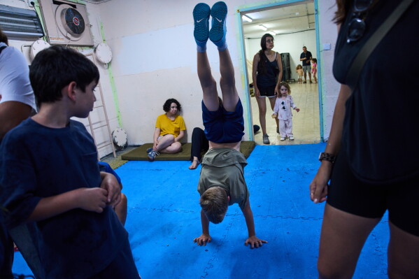 People take shelter as air raid sirens warning of incoming Iranian missiles in Ramat Gan, Israel, Monday, June 8, 2026. (AP Photo/Oded Balilty)