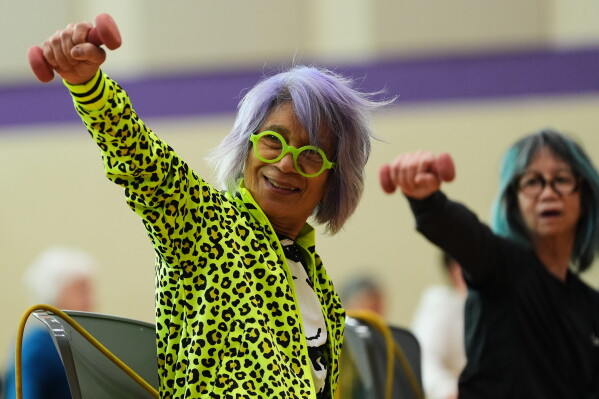 Lili Bonilla raises light weights during an exercise class for older adults led by instructor Bengie Santos, 72, at the Dale Turner Family YMCA, April 30, 2026, in Shoreline, Wash. (AP Photo/Lindsey Wasson)