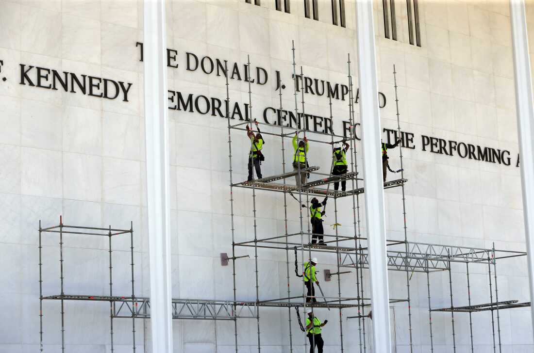Workers construct scaffolding below the John F. Kennedy Center for the Performing Arts sign on Friday in Washington.