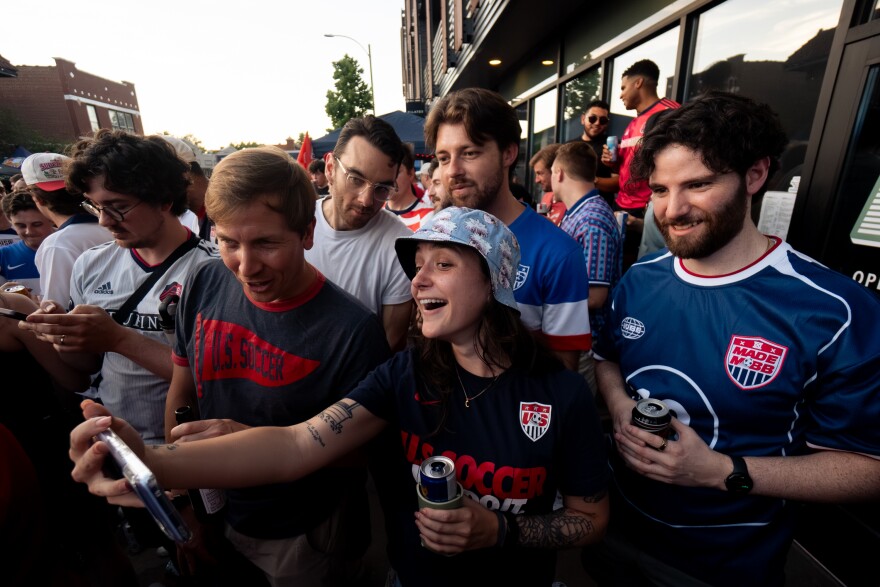 United States fans watch the USMNT take on Paraguay on their phones during a FIFA World Cup watch party outside of Amsterdam Tavern on Friday, June 12, 2026, in south St. Louis. Moments prior, the outdoor watch party’s stream cut due to a power issue.
