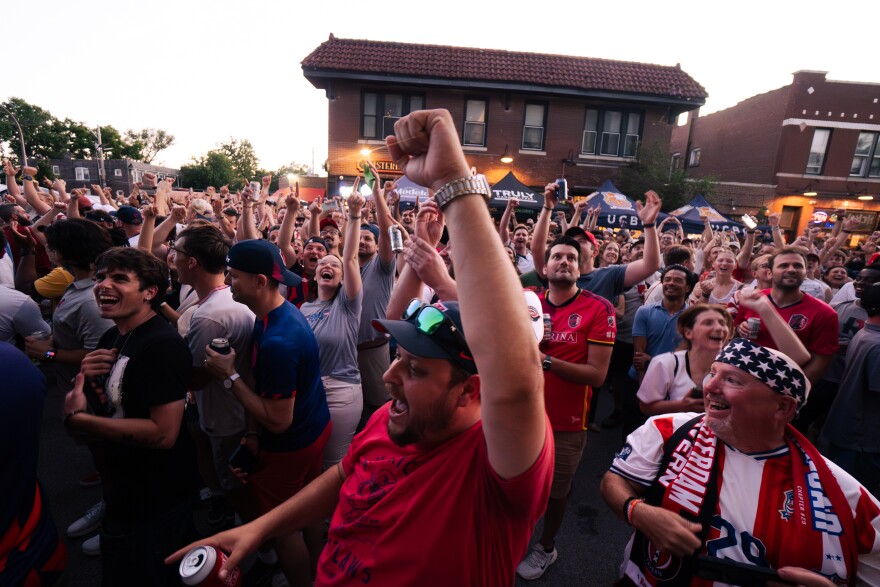United States fans chant “MVP” while XYZ hold their television towards the crowd after the outdoor FIFA World Cup watch party’s stream cut due to a power issue on Friday, June 12, 2026, outside of Amsterdam Tavern in south St. Louis.