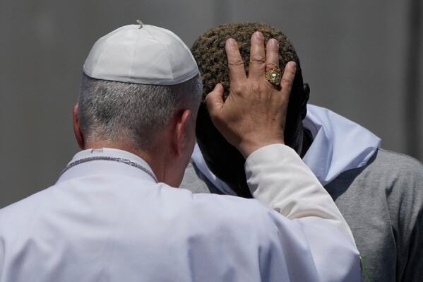 Pope Leo XIV blesses a migrant during a meeting with organizations working with migrants in Arguineguin at the Canary Islands, Spain, Thursday, June 11, 2026. (AP Photo/Alessandra Tarantino)