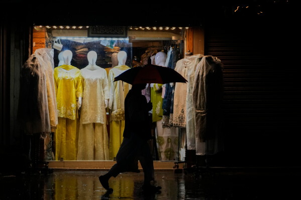 A man walks in the rain while holding an umbrella in Srinagar, in Indian-controlled Kashmir, Thursday, June 11, 2026. (AP Photo/Mukhtar Khan)