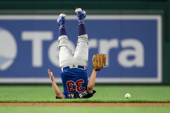 Rep. Pete Aguilar, D-Ca. rolls over after he missed a ball during the congressional baseball game against the republicans, Wednesday, June 10, 2026, in Washington. (AP Photo/Nick Wass)
