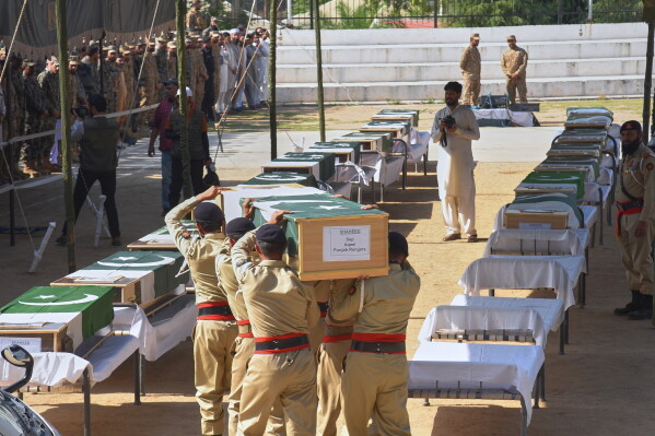 Army soldiers carry a flag-wrapped casket of a military person killed in Wednesday's helicopter crash, during a funeral prayer, in Muzaffarabad, the capital of Pakistan-administered Kashmir, Thursday, June 11, 2026. (AP Photo/M.D. Mughal)