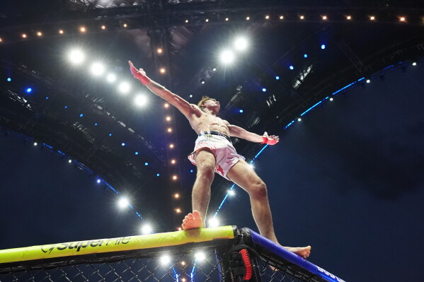 Diego Lopes, stands on the ring fence during the featherweight bout against Steve Garcia during UFC Freedom 250 on the South Lawn of the White House, Sunday, June 14, 2026, in Washington. (AP Photo/Alex Brandon)