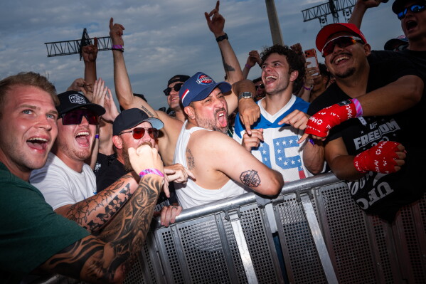 Nic Becker, of Houston, shows off a Freedom 250 tattoo he got earlier in the day during UFC Fan Fest on the White House Ellipse ahead of the fights on the South Lawn, Sunday, June 14, 2026, in Washington. (AP Photo/Allison Robbert)