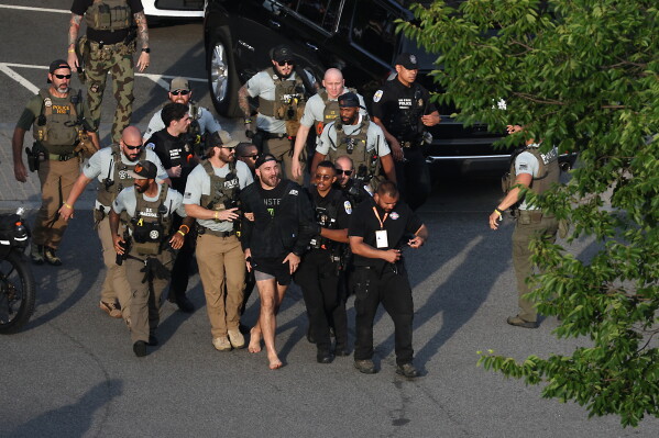 MMA fighter Sean Strickland is escorted out of the UFC Freedom 250 Fan Fest on The Ellipse by U.S. Secret Service and other law enforcement ahead of UFC Freedom 250 on the South Lawn of the White House on Sunday, June 14, 2026, in Washington. (Kevin Dietsch/Pool Photo via AP)