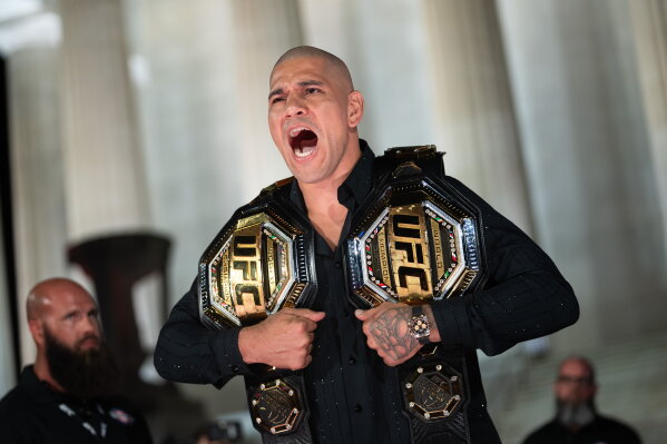 UFC fighter Alex Pereira holds his UFC belts at a UFC news conference at the Lincoln Memorial, ahead of Sunday's fight on the South Lawn of the White House, Friday, June 12, 2026, in Washington. (AP Photo/Allison Robbert)