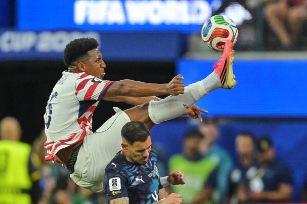 United States' Alex Freeman, top, reaches for the ball over Paraguay's Antonio Sanabria during the World Cup Group D soccer match in Inglewood, Calif., near Los Angeles, Friday, June 12, 2026. (AP Photo/Jayne Kamin-Oncea)