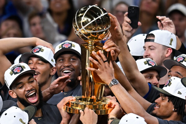 The New York Knicks celebrate with the Larry O'Brien Championship Trophy after defeating the San Antonio Spurs in Game 5 of the NBA Finals basketball series, Saturday, June 13, 2026, in San Antonio. (AP Photo/Darren Abate)