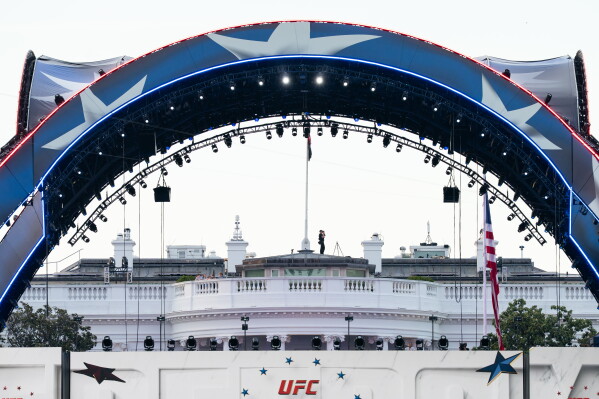 Security at the White House looks through a pair of binoculars during the UFC Fan Fest on the White House Ellipse ahead of Sunday's fight on the South Lawn, June 13, 2026, in Washington. (AP Photo/Allison Robbert, File)