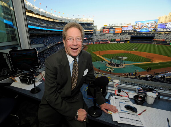In this Sept. 25, 2009 file photo shows New York Yankees broadcaster John Sterling sitting in his booth before a baseball game against the Boston Red Sox at Yankee Stadium in New York. (AP Photo/Bill Kostroun, file)