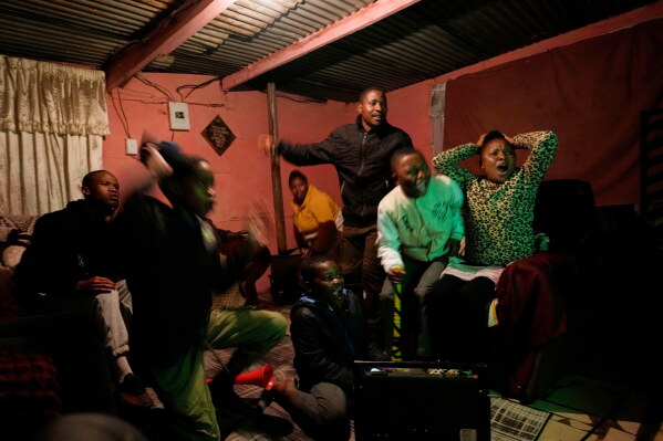 A family watches the opening soccer match of the FIFA World Cup 2026 between Mexico and South Africa, in Vereeniging, South Africa, Thursday, June 11, 2026. (AP Photo/Themba Hadebe)