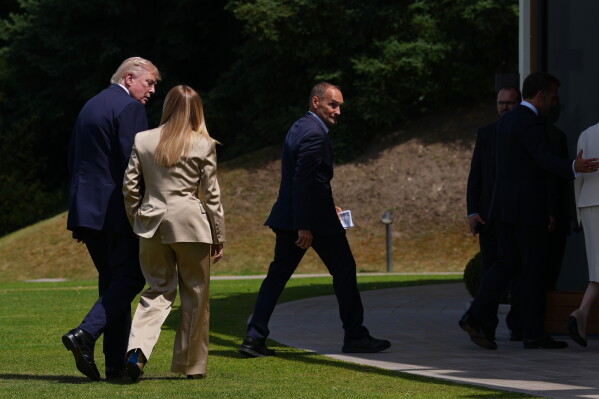 U.S. President Donald Trump, left, speaks with Italian Prime Minister Giorgia Meloni, second left, after a group photo of G7 leaders and invited nations during the G7 summit in Evian-les-Bains, France, Tuesday, June 16, 2026. (AP Photo/Thibault Camus)