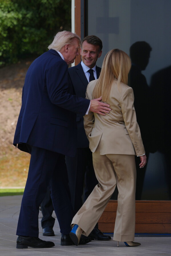 U.S. President Donald Trump, left, speaks with French President Emmanuel Macron, center, and Italian Prime Minister Giorgia Meloni after a group photo of G7 leaders and invited nations during the G7 summit in Evian-les-Bains, France, Tuesday, June 16, 2026. (AP Photo/Thibault Camus)