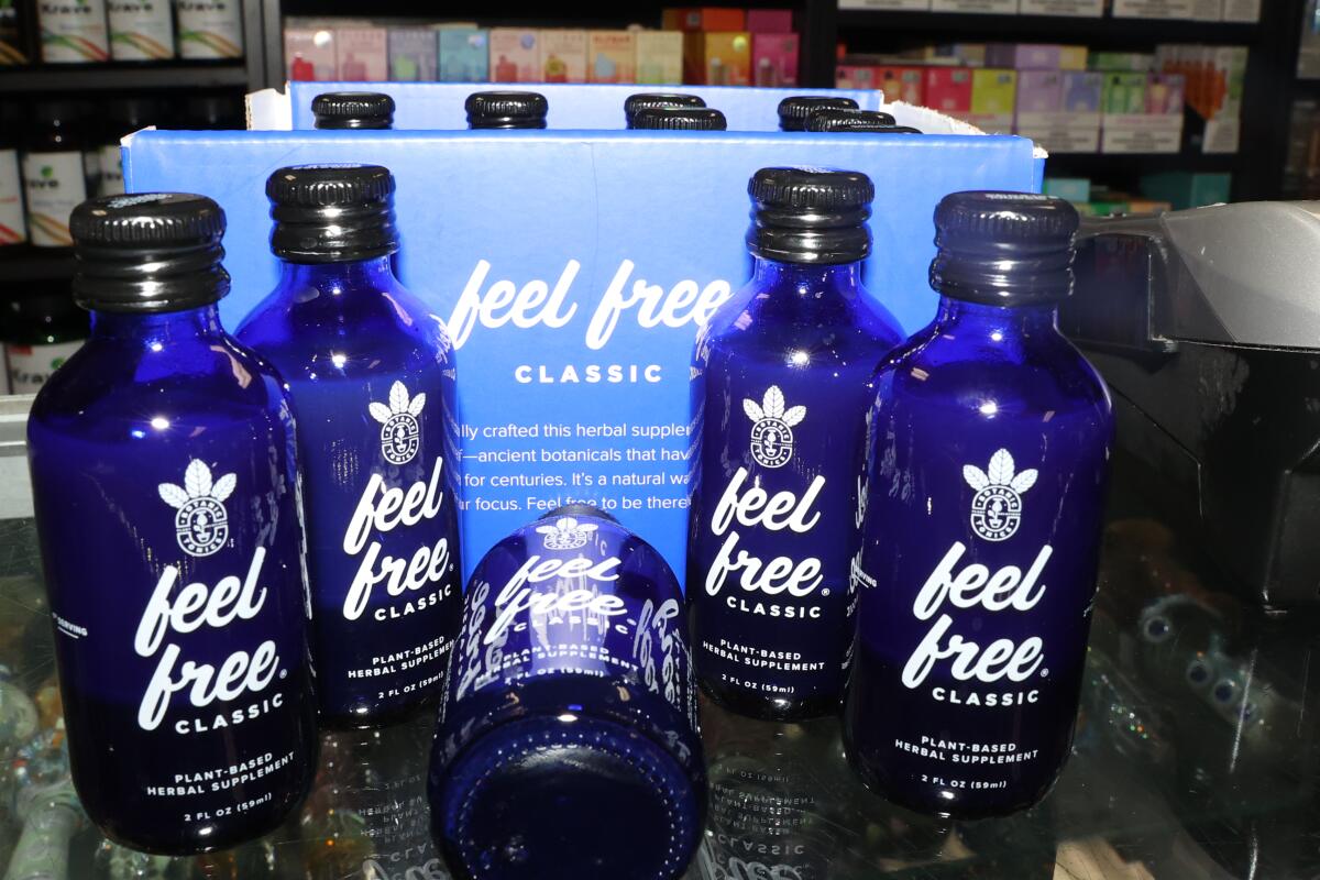 Blue bottles labeled "feel free" sit on a counter