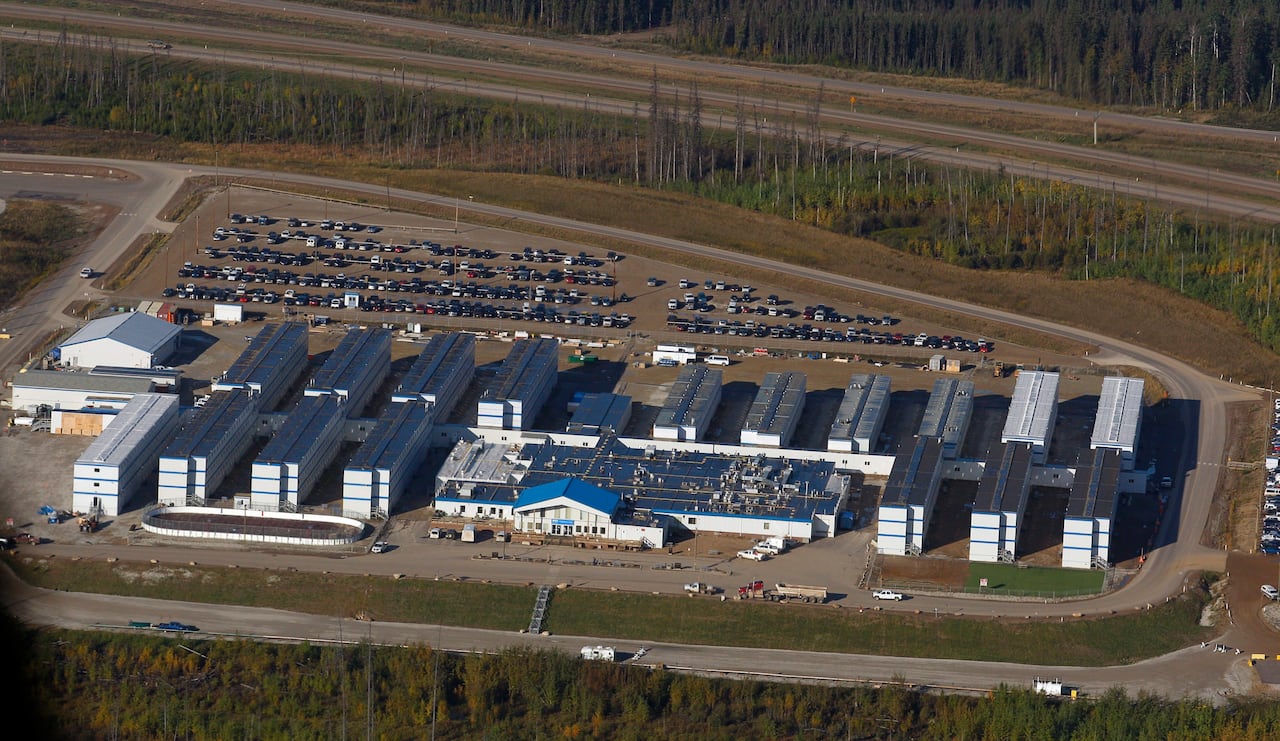 Rectangular buildings connected to form a large complex in the middle of a parking lot