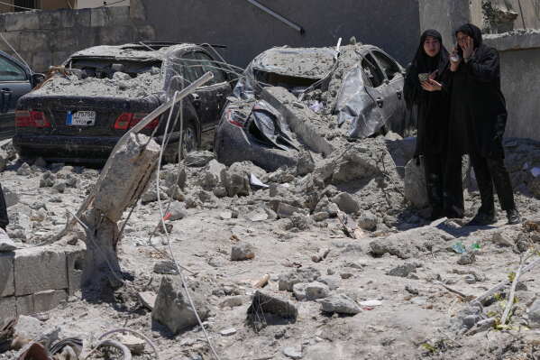 Relatives of missed victims weep, as they gather at the site of destroyed buildings that were hit in an Israeli airstrike in Qannarit village, southern Lebanon, Saturday, June 20, 2026. (AP Photo/Mohammed Zaatari)