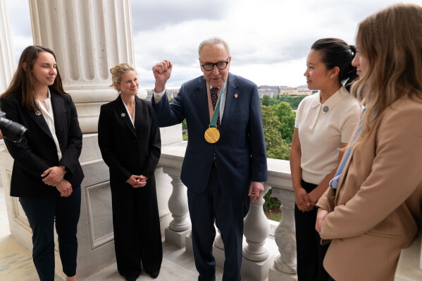 Senate Minority Leader Chuck Schumer, D-N.Y., speaks with Olympians Julia Kern, from left, Jessie Diggins, Bea Kim and Olivia Giaccio, during a meeting to advocate for clean air, clean water and a healthy planet on Capitol Hill, Tuesday, June 23, 2026, in Washington. (AP Photo/Jose Luis Magana)