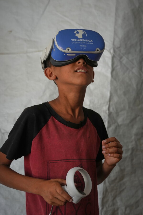 ALTERNATIVE CROP OF XOB112.- Palestinian children participate in a psychological support session using a virtual reality headset in a tent operated by a medical technology team in Zawaida, central Gaza Strip, Wednesday, June 17, 2026. (AP Photo/Abdel Kareem Hana)