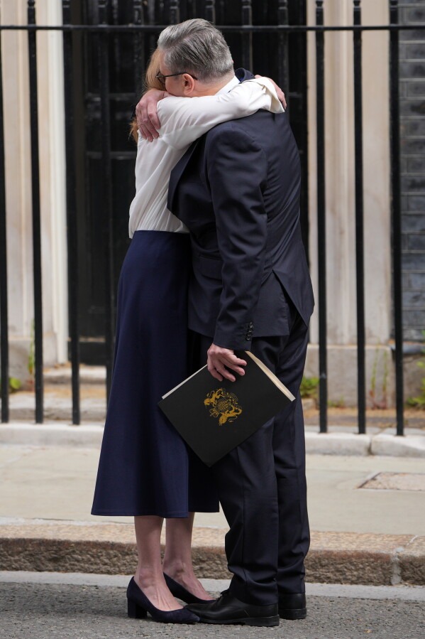 Britain's Prime Minister Keir Starmer hugs his wife Victoria outside 10 Downing Street after announcing his resignation to the media in London, Monday, June 22, 2026.(AP Photo/Kin Cheung)