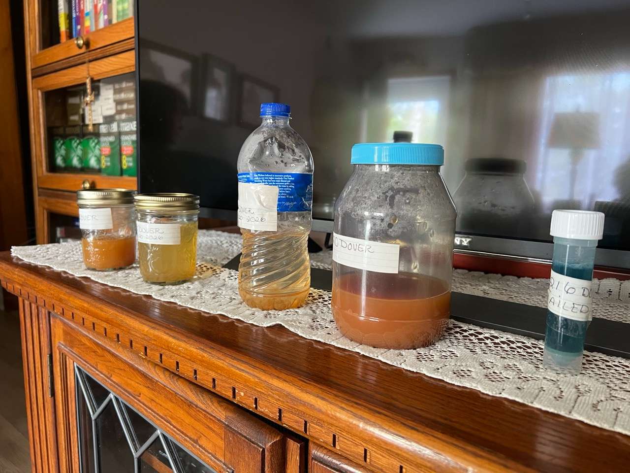 Jars, a bottle and a capsule of discolored, undrinkable and unsafe water shown up along the Dover Drive neighborhood in west Salina - Photo by Nicolas Fierro