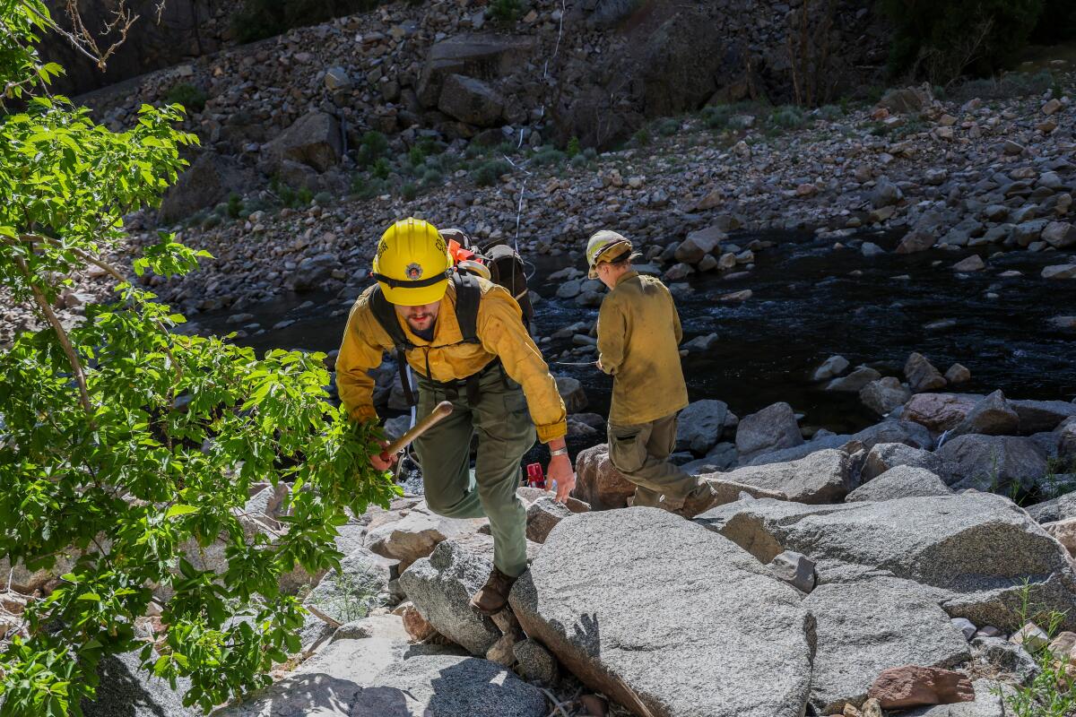 A firefighter crosses a section of the Colorado River