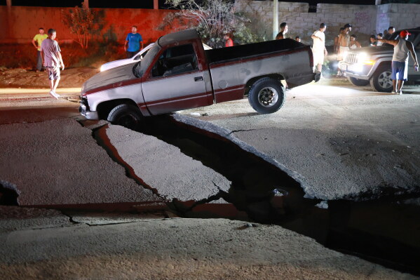A vehicle is trapped in a fissure caused by an earthquake in La Guaira, Venezuela, Thursday, June 25, 2026. (AP PhotoJavier Campos)