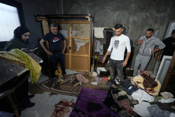 Palestinians inspect the bloodstained bedroom of Mustafa al-Khatib who was killed during an Israeli army raid at his home in the early morning, in the West Bank village of Sarta, west of Salfit, Thursday, June 25, 2026. (AP Photo/Majdi Mohammed)
