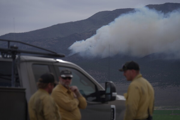 Firefighters gather near the Cottonwood Fire near Junction, Utah, on Friday, June 26, 2026. (AP Photo/Ty ONeil)