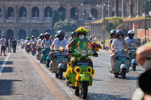 Vespa enthusiasts parade in front of the Colosseum during celebrations for the 80th anniversary of the Vespa scooter, in Rome, Saturday, June 27, 2026. (AP Photo/Alessandra Tarantino)