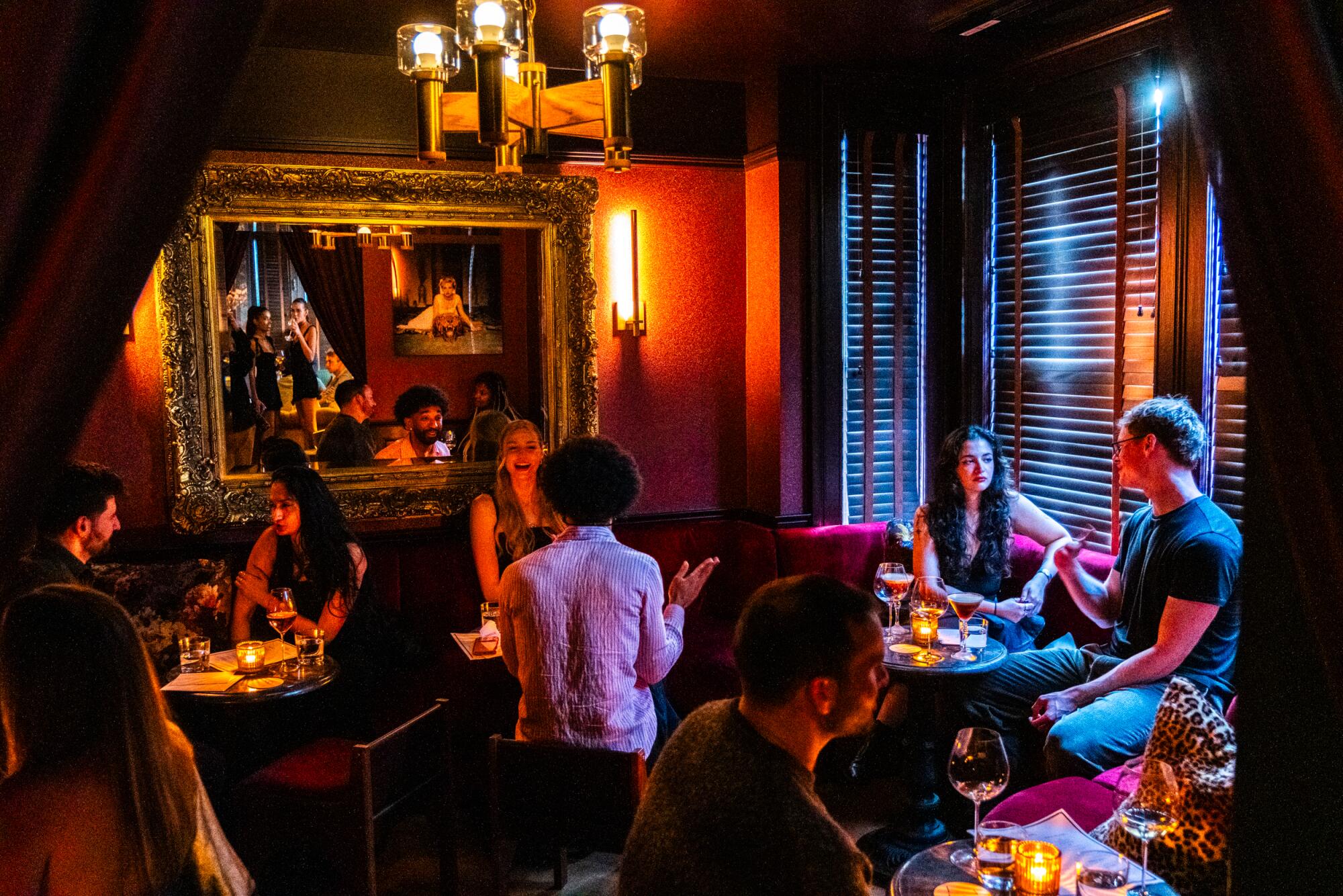 People sit and talk to each other in a dimly lit room.