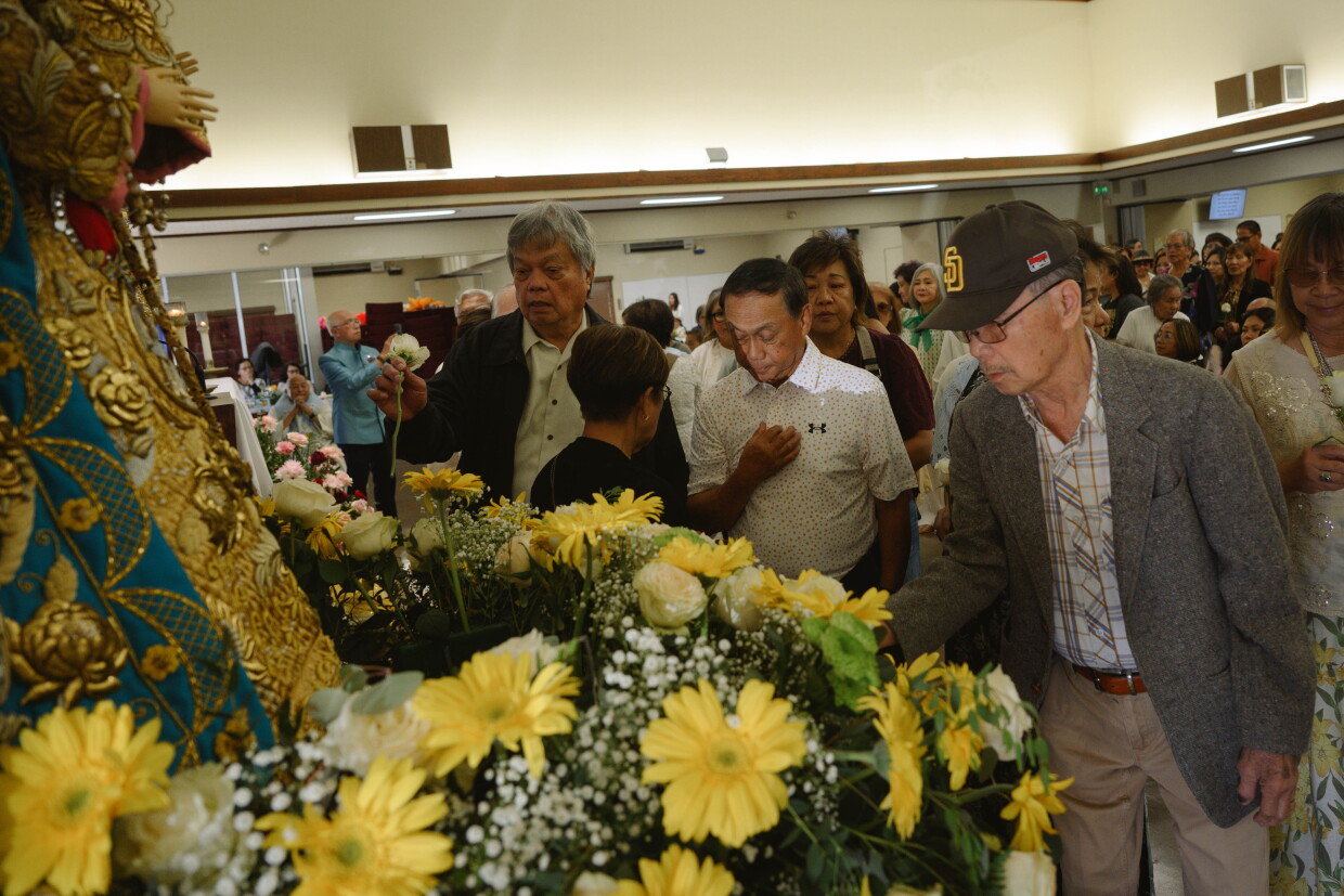 Congregation members from St. Mary’s Catholic Church in National City offer roses during an annual fiesta in honor of Our Lady of the Rosary of Manaoag, an image of the Virgin Mary with deep roots in the Pangasinan province of the Philippines, on May 30, 2026.