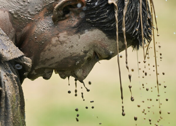 A boy washes his hair and face after playing in the mud in a paddy field during Asar Pandra, the annual paddy planting festival, in Kathmandu, Nepal, Monday, June 29, 2026. (AP Photo/Niranjan Shrestha)