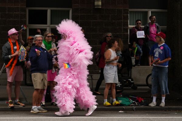 A person calling themselves "Seattle Cloud Guy" jogs by during the Pride Parade, Sunday, June 28, 2026, in Seattle. (AP Photo/Lindsey Wasson)