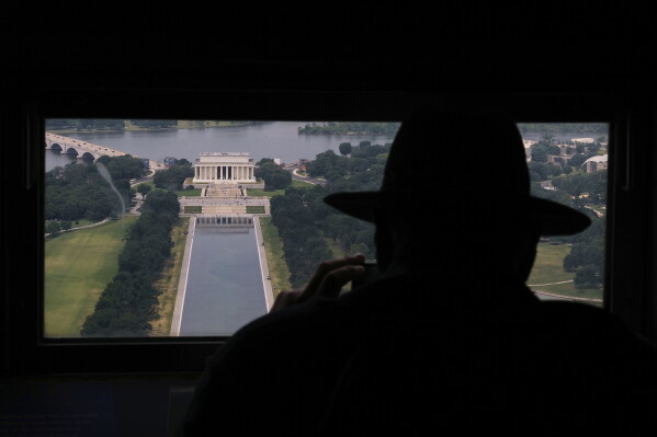 David Boczar photographs the Lincoln Memorial and the Lincoln Memorial Reflecting Pool from a window at the top of the Washington Monument, Friday, June 26, 2026, in Washington. (AP Photo/Carolyn Kaster)