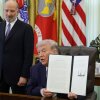 President Trump holds up an executive order to limit mail-in voting as Commerce Secretary Howard Lutnick looks on in the White House’s Oval Office in March.